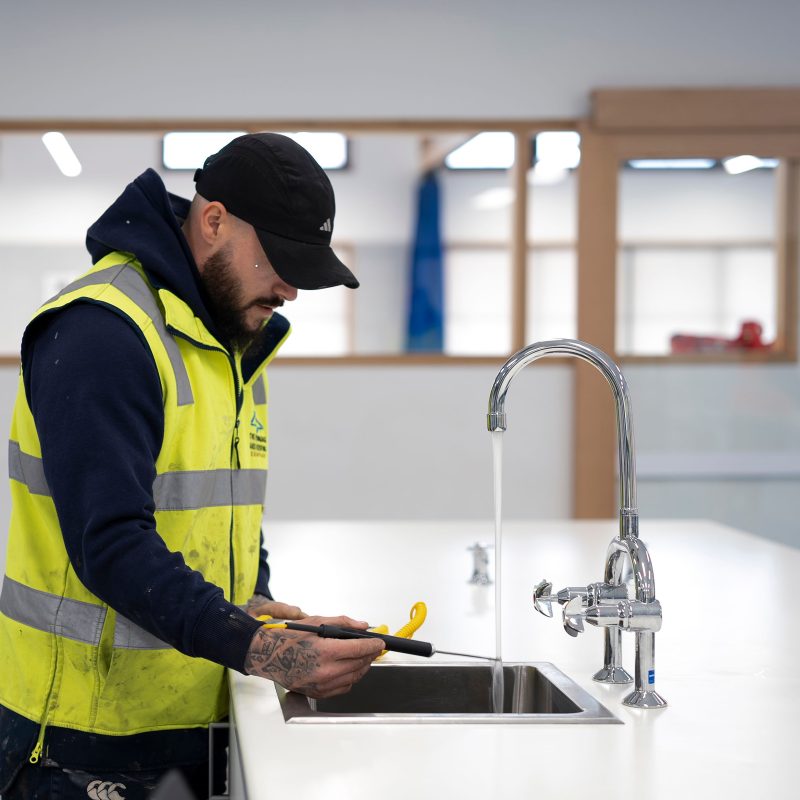 Plumber repairing a kitchen tap