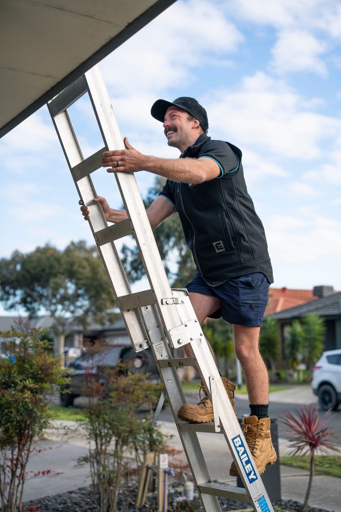Roof plumber setting up a ladder for a roof inspection