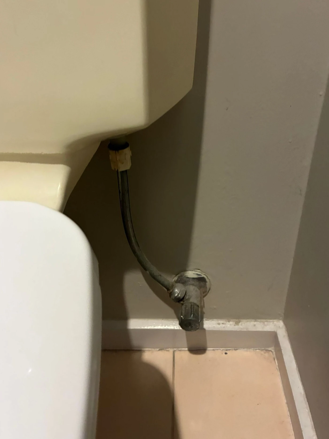 Old rigid copper pipe with corrosion at the toilet cistern connection